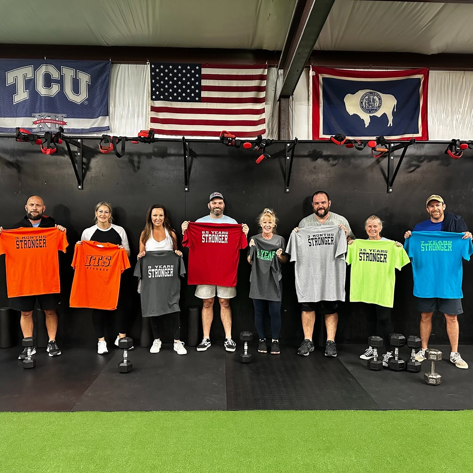 I.T.S. members holding shirts marking months and years stronger
